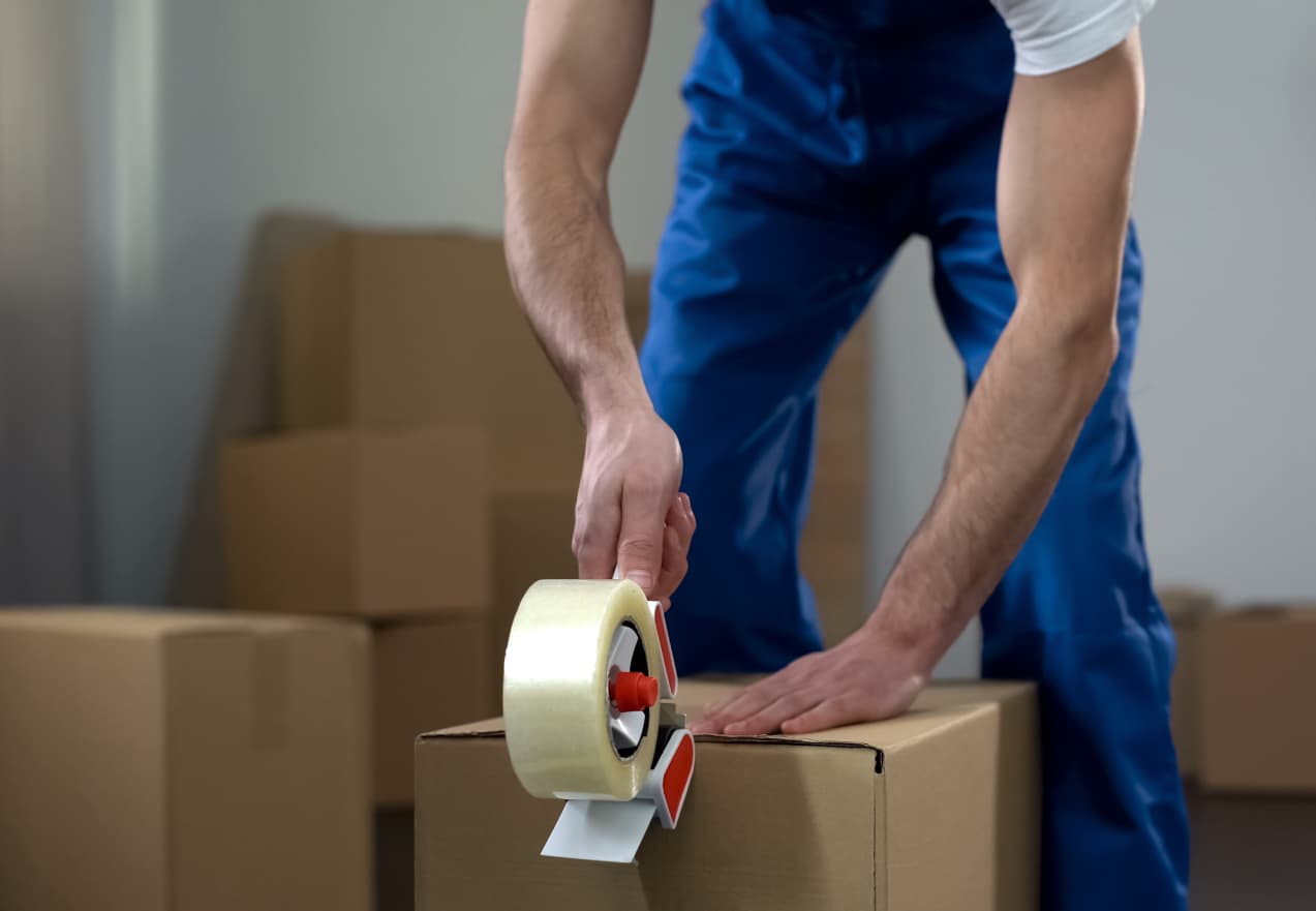 man taping a box shut